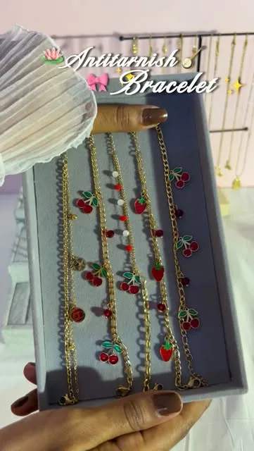 Saaj's cherry charm bracelets on a display tray